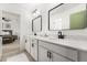 Bathroom featuring double vanity, black hardware and mirrors, and ensuite entrance to main bedroom at 5458 Carrara Ct, St Cloud, FL 34771