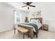 Bright bedroom featuring neutral walls, a ceiling fan, window, bed, bench, and side table at 5458 Carrara Ct, St Cloud, FL 34771