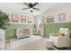 Charming Bedroom with green wainscoting, white crib, and cozy rocking chair near a bright window at 5458 Carrara Ct, St Cloud, FL 34771