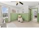 Comfortable bedroom with sage green wainscoting, white chair, and natural light at 5458 Carrara Ct, St Cloud, FL 34771