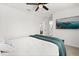 Bedroom with a bed, TV, ceiling fan and a glimpse into the ensuite bathroom, creating a serene space at 5458 Carrara Ct, St Cloud, FL 34771