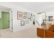 Bright hallway with a collection of wall art, tan carpet, and a leather chair near the staircase at 5458 Carrara Ct, St Cloud, FL 34771
