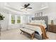 Spacious main bedroom features a tray ceiling, ceiling fan, bench, and large windows at 5458 Carrara Ct, St Cloud, FL 34771