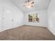 Carpeted bedroom with ceiling fan and window overlooking outdoor greenery at 6042 Brookhill Cir, Orlando, FL 32810