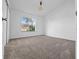 Carpeted bedroom featuring a large window with backyard views and a ceiling fan at 6042 Brookhill Cir, Orlando, FL 32810