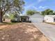 Charming single-story home features a two-car garage and well-maintained front yard with mature trees at 6042 Brookhill Cir, Orlando, FL 32810