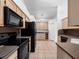 The kitchen features ample cabinet space, black appliances, and tile flooring at 6042 Brookhill Cir, Orlando, FL 32810