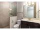 Bathroom features a glass shower, decorative tile, dark cabinet, mirror, and modern lighting at 625 Pavia Loop, Lake Mary, FL 32746