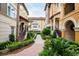 Exterior view of two-story townhomes with landscaping, sidewalks, and front staircases at 625 Pavia Loop, Lake Mary, FL 32746