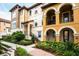 Two-story townhome with a combination of paint and stone features, balconies, and professional landscaping at 625 Pavia Loop, Lake Mary, FL 32746