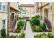 Exterior of two-story townhomes with desert landscaping, sidewalks, and front staircases at 625 Pavia Loop, Lake Mary, FL 32746
