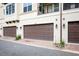 This photo features an attached multi-car garage, rock landscaping, and modern light fixtures at 625 Pavia Loop, Lake Mary, FL 32746