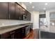 Beautiful kitchen with stainless steel oven and appliances, dark cabinets and stone countertops at 625 Pavia Loop, Lake Mary, FL 32746