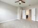 Spacious carpeted bedroom with ceiling fan and views of the ensuite bathroom at 625 Pavia Loop, Lake Mary, FL 32746