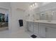 Elegant bathroom featuring double sinks, quartz countertop, and a view into the walk-in closet at 636 San Augusto Dr, Kissimmee, FL 34759