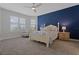 Bright bedroom features blue accent wall, neutral carpet, and an accent chair by the light-filled windows at 636 San Augusto Dr, Kissimmee, FL 34759