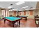 Billiards room featuring two pool tables, with wooden floors and ample lighting at 636 San Augusto Dr, Kissimmee, FL 34759