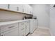Well-lit laundry room with white cabinets, countertop space, and modern washer and dryer at 636 San Augusto Dr, Kissimmee, FL 34759
