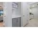 Mud room with white walls, gray cabinets, shelves, hooks and a door leading to the laundry room at 636 San Augusto Dr, Kissimmee, FL 34759