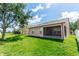 Spacious backyard featuring lush green grass, a screened-in porch, and mature trees at 6728 Duncaster St, Windermere, FL 34786
