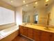 Bright bathroom featuring a large vanity, garden tub and separate glass shower at 6728 Duncaster St, Windermere, FL 34786