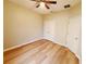 This bedroom features wood flooring, a ceiling fan, and a double-door closet at 6728 Duncaster St, Windermere, FL 34786