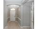 Elegant foyer with neutral tile flooring, classic archways, and a modern light fixture at 6728 Duncaster St, Windermere, FL 34786