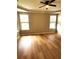 Spacious main bedroom with wood floors, large windows, and a modern ceiling fan at 6728 Duncaster St, Windermere, FL 34786