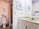Cozy bathroom featuring white cabinetry with marbled countertops and a framed beach-themed artwork at 721 Fairway Dr, New Smyrna Beach, FL 32168
