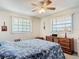 Comfortable bedroom with natural light, ceiling fan, and classic wooden dresser furniture at 721 Fairway Dr, New Smyrna Beach, FL 32168