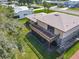 Aerial view of a two-story home featuring a spacious deck and stone accents and green backyard at 721 Fairway Dr, New Smyrna Beach, FL 32168