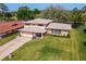Aerial view of a well-maintained home with lush landscaping, showcasing its curb appeal and architectural details at 721 Fairway Dr, New Smyrna Beach, FL 32168