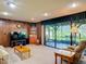 Well-lit living room with a view of the screened lanai and landscaped backyard at 721 Fairway Dr, New Smyrna Beach, FL 32168