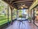 Relaxing screened patio with a table and chairs, offering a serene outdoor space with lush greenery views at 721 Fairway Dr, New Smyrna Beach, FL 32168