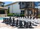 The backyard features a pool, daybeds, chess set, and outdoor ping pong table for ultimate relaxation and entertainment at 8180 Valhalla Ter, Reunion, FL 34747