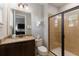 Well-lit bathroom featuring glass enclosed shower, granite vanity, and unique decorative details at 8180 Valhalla Ter, Reunion, FL 34747