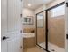 Modern bathroom with a glass-enclosed shower, soaking tub, and neutral tile surround at 8180 Valhalla Ter, Reunion, FL 34747