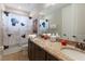 Bathroom featuring double sinks, granite countertops, and a patterned Mickey Mouse shower curtain at 8180 Valhalla Ter, Reunion, FL 34747