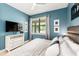 Comfortable bedroom with accent wall, a well lit window, with a mounted flatscreen TV at 8180 Valhalla Ter, Reunion, FL 34747