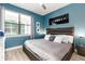 Stylish bedroom with accent wall, a well lit window, and padded headboard queen bed at 8180 Valhalla Ter, Reunion, FL 34747
