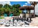This backyard features a life-size chess board with a tiki bar and Adirondack chairs surrounding the recreational area at 8180 Valhalla Ter, Reunion, FL 34747