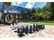 Backyard features include a pool, oversized chess set, cabana, and lush landscaping, perfect for outdoor relaxation and games at 8180 Valhalla Ter, Reunion, FL 34747