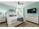 Comfortable main bedroom with accent wall, white furniture, and a large mounted flatscreen TV at 8180 Valhalla Ter, Reunion, FL 34747