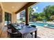 Enjoy outdoor dining by the pool with a long table and access to the jacuzzi and backyard at 8180 Valhalla Ter, Reunion, FL 34747