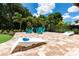 A spacious patio features Adirondack chairs, a putting green, and a lounge area for outdoor relaxation at 8180 Valhalla Ter, Reunion, FL 34747