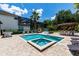Backyard features a pool, ping pong table, spa, tiki bar, cabana, chess set, and lush landscaping for entertainment at 8180 Valhalla Ter, Reunion, FL 34747