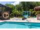 Backyard with a pool, oversized chess set, cabana, and basketball hoop, creating a fun and relaxing outdoor space at 8180 Valhalla Ter, Reunion, FL 34747