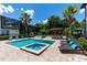 A luxurious backyard with a pool, spa, tiki bar, lounge chairs, and lush landscaping, perfect for relaxation and entertaining at 8180 Valhalla Ter, Reunion, FL 34747