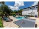 Backyard features a pool, ping pong table, spa, tiki bar, cabana, chess set, and lush landscaping for entertainment at 8180 Valhalla Ter, Reunion, FL 34747
