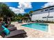 Backyard featuring a pool, spa, lounge chairs, tiki bar, cabana, chess set, and lush landscaping for ultimate relaxation at 8180 Valhalla Ter, Reunion, FL 34747